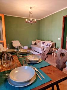 聖傑可莫的住宿－WH-Bilocale Green Roburent，用餐室配有带盘子和酒杯的桌子