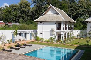 a house with a swimming pool next to a building at Madilao Hotel in Luang Prabang
