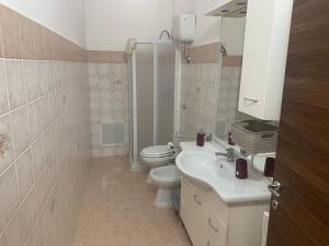 bagno bianco con servizi igienici e lavandino di HOLIDAY PATRIZIA'S HOME 2.0 a San Giorgio Ionico