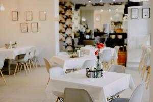 un comedor con mesas blancas y sillas blancas en B&B HOTEL Piotrków Trybunalski, en Piotrków Trybunalski