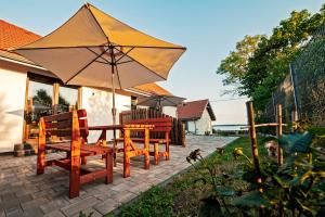 eine Terrasse mit einem Tisch, Stühlen und einem Sonnenschirm in der Unterkunft Apartamenty - Grądzkie 19 in Grądzkie