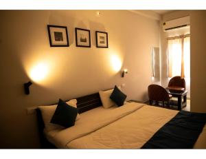 ブバネーシュワルにあるMy Homes and Hotels, Bhubaneswar, Odishaのベッドルーム1室(ベッド1台、テーブル、椅子付)