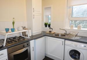 a white kitchen with a sink and a dishwasher at Welsh Drive Apartment by Klass Living Blantyre in High Blantyre
