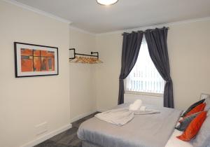 um quarto com uma cama e uma janela em Welsh Drive Apartment by Klass Living Blantyre em High Blantyre
