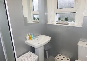 a white bathroom with a sink and a toilet at Welsh Drive Apartment by Klass Living Blantyre in High Blantyre