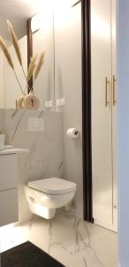 La salle de bains blanche est pourvue de toilettes et d'un miroir. dans l'établissement Apartments Wroc'LOVE by me & Mosiężna & Free Garage & Self Check in 24H, à Wrocław