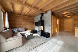 a living room with a couch and a fireplace at Chalet Selun in Wildhaus