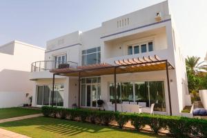 a large white house with an open patio at Private 5 Bed Villa / Next to Lagoon in Seeb