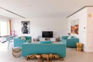 a living room with two blue couches and a tv at Private 5 Bed Villa / Next to Lagoon in Seeb