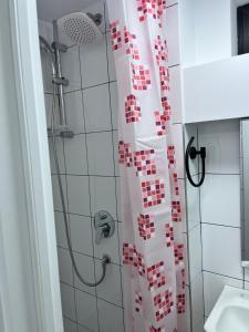 a shower with a red and white shower curtain in a bathroom at Apartament Eroilor in Lunca Cetăţuii +15 photos