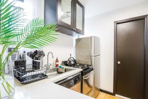 uma cozinha com um frigorífico de aço inoxidável e um lavatório em Apartment 189: Upper East Side em Nova York