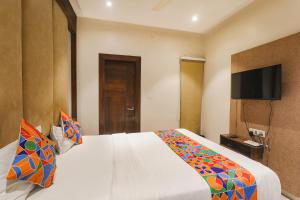 MuthiganjにあるFabHotel Stay Inn Iのベッドルーム1室(ベッド1台、壁掛けテレビ付)