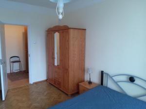 a bedroom with a wooden cabinet and a bed at Gonsiori 3 City Center Apartment in Tallinn