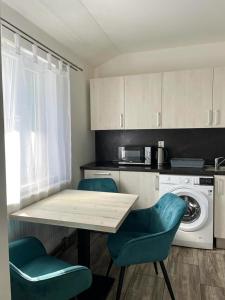 a kitchen with a table and two chairs and a washing machine at Apartmány Plzeň Zábělá 69 in Plzeň