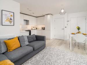 uma sala de estar com um sofá cinzento e uma cozinha em Pass the Keys Central and Modern 2 Bed Flat 6ppl em High Wycombe