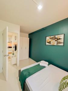Un dormitorio con una pared verde y una cama en 2 Bedroom and 1 Bedroom Apartments with Private Pool and Gym en Puerto Princesa