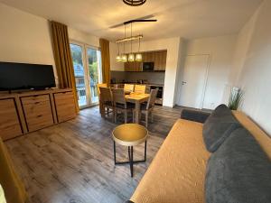 多尼蒙拉沃的住宿－Apartmán Pod sjezdovkami，带沙发和桌子的客厅以及厨房。