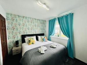 Elmbank Avenue House by Klass Living Uddingston في أودينغستن: غرفة نوم عليها سرير وفوط