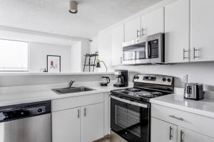a white kitchen with a stove and a sink at Streeterville Studio w Pool Gym nr Navy Pier CHI-788 in Chicago
