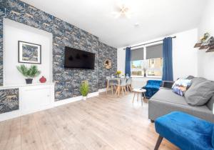 a living room with a couch and a tv on a wall at Sanderson Apartment by Klass Living Uddingston in Uddingston