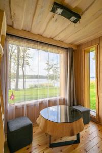巴爾維的住宿－Pirtsmāja diviem Līčezeri，客房设有桌子和大窗户。