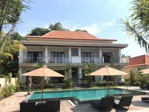 a villa with a swimming pool and two umbrellas at Londo House in Ubud
