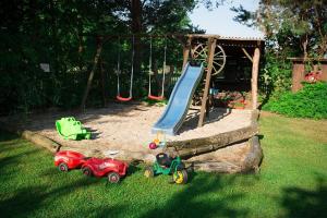 ein Spielplatz mit zwei Spielzeugautos und einer Rutsche in der Unterkunft Spreewaldferienwohnungen Stein - Ferienwohnungen in Byhlen