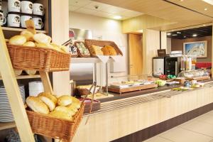 a bakery with baskets of bread on a counter at B&B HOTEL Wrocław Centrum in Wrocław