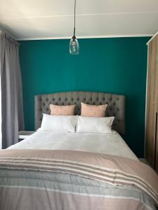 a bedroom with a large bed with a green wall at Cosy Waterfall Midrand Apartment in Midrand +41 photos
