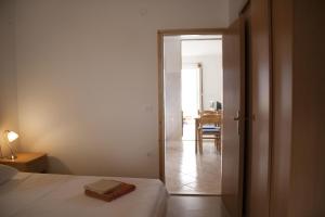 a bedroom with a bed and a door leading to a dining room at House Baglija in Lumbarda