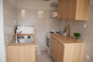 a small kitchen with a sink and a stove at House Baglija in Lumbarda