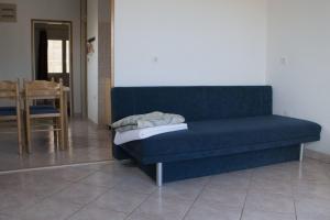 a blue couch sitting in a room with a table at House Baglija in Lumbarda