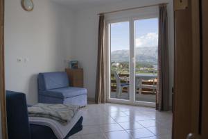 a living room with a chair and a sliding glass door at House Baglija in Lumbarda
