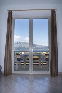 a sliding glass door with a view of the ocean at House Baglija in Lumbarda
