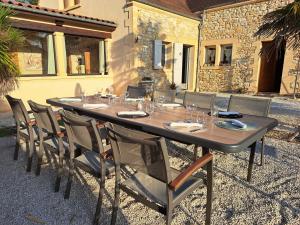 - une grande table avec des chaises et des verres dans l'établissement La Barde Montfort, votre maison d'hôtes à 4 kms de Sarlat Dordogne, à Vitrac