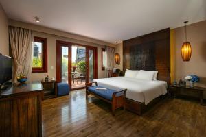 a bedroom with a bed and a living room with a television at Oriental Suites Hotel & Spa in Hanoi