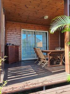 eine Holzterrasse mit einem Tisch und Stühlen darauf in der Unterkunft Le Chalet Kréol in Saint-Joseph