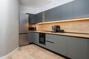 a kitchen with white cabinets and stainless steel appliances at Pensiunea Samaha in Moieciu de Sus