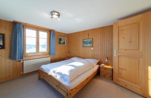 sypialnia z dużym łóżkiem i oknem w obiekcie Steirüti 15 w mieście Wildhaus