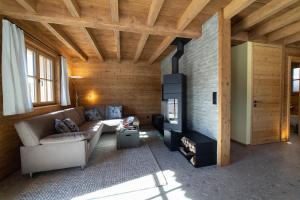 a living room with a couch and a fireplace at Chalet Zuestoll in Wildhaus