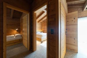 a wooden room with two beds in it at Chalet Zuestoll in Wildhaus