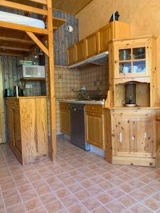 una cucina con armadi in legno e pavimento piastrellato di Studio Avec belle terrasse proche des pistes a Uvernet