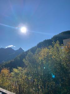 un sole che splende sugli alberi in montagna di Studio Avec belle terrasse proche des pistes a Uvernet