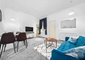 uma sala de estar com um sofá azul e uma mesa em Garturk Apartment by Klass Living Coatbridge em Coatbridge