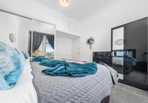 sypialnia z łóżkiem z niebieskimi kocami w obiekcie Garturk Apartment by Klass Living Coatbridge w mieście Coatbridge