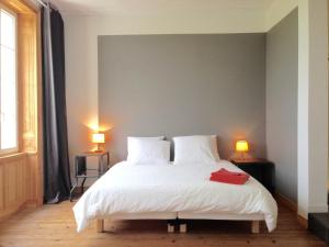 ein Schlafzimmer mit einem weißen Bett mit zwei Lampen in der Unterkunft Le Dojo du Plessis in Mareuil