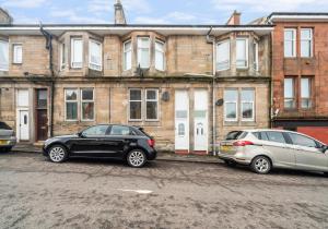 two cars parked in front of a building at Garturk Apartment by Klass Living Coatbridge in Coatbridge