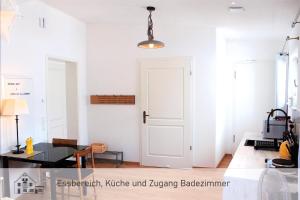 ein Wohnzimmer mit einer weißen Tür und einem Tisch in der Unterkunft Barrierefreie Ferienwohnung ideal für Paare in Dießen am Ammersee