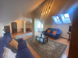 a living room with a blue couch and a table at Casa Vale de Azibo in Macedo de Cavaleiros
