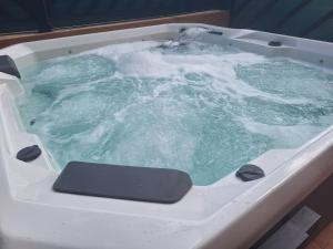 a bath tub filled with green water with foam at Villadunas - with luxury hot tub in Corralejo
